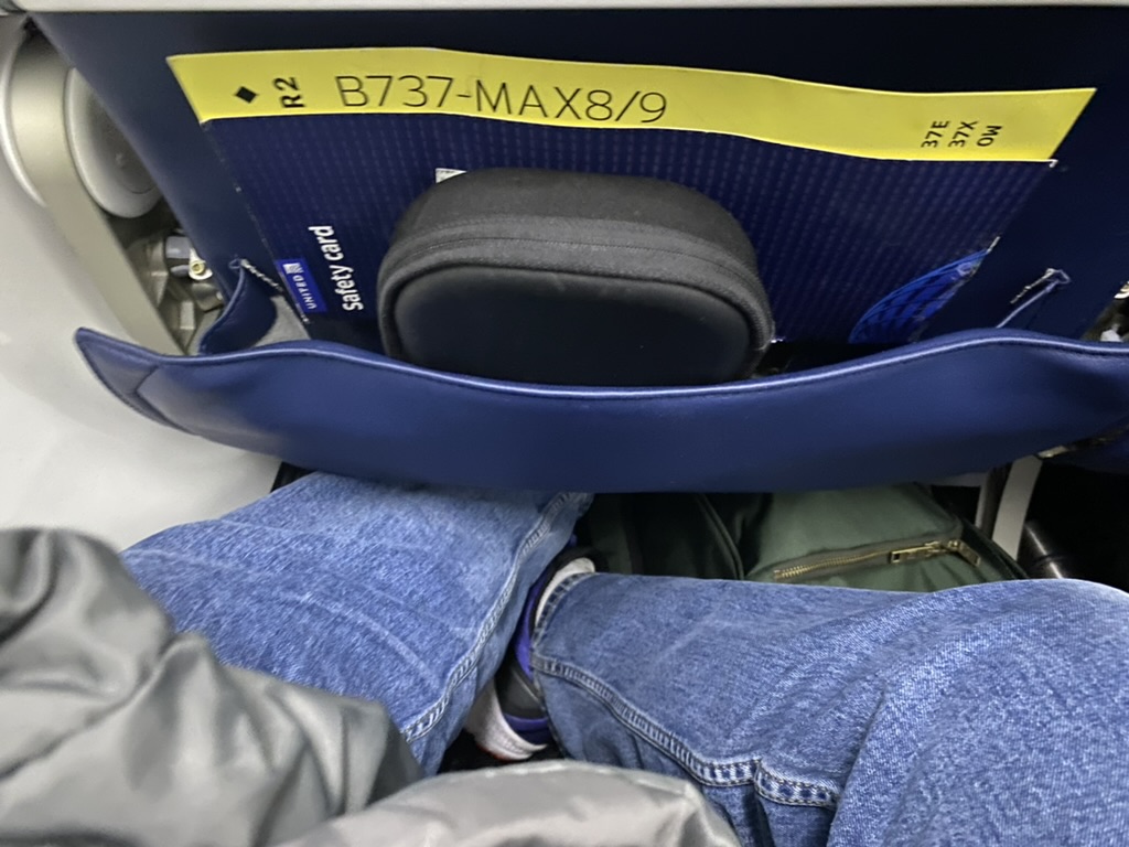 a person's legs in a seat with a bag inside