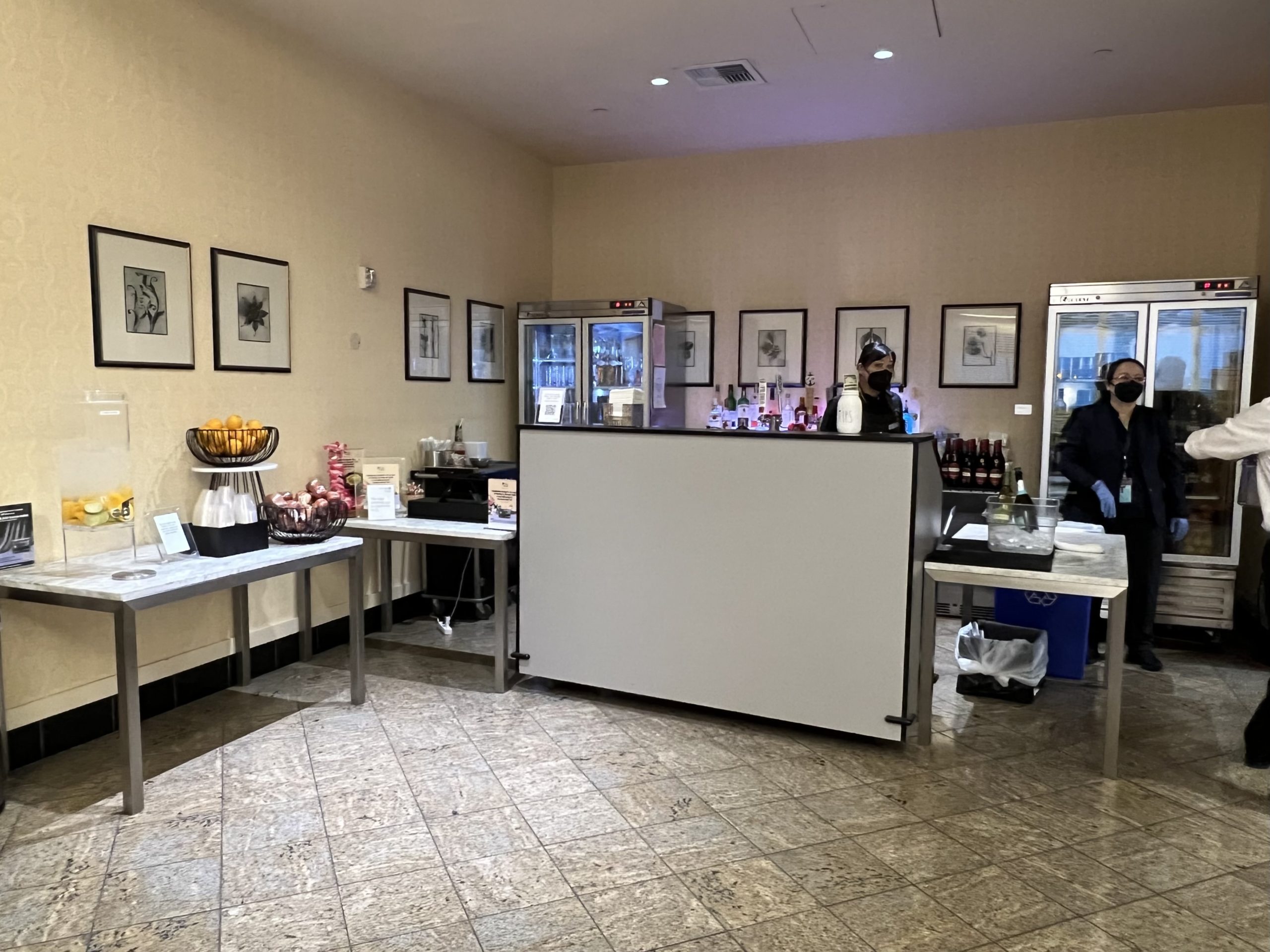 a man standing behind a counter in a room with pictures on the wall