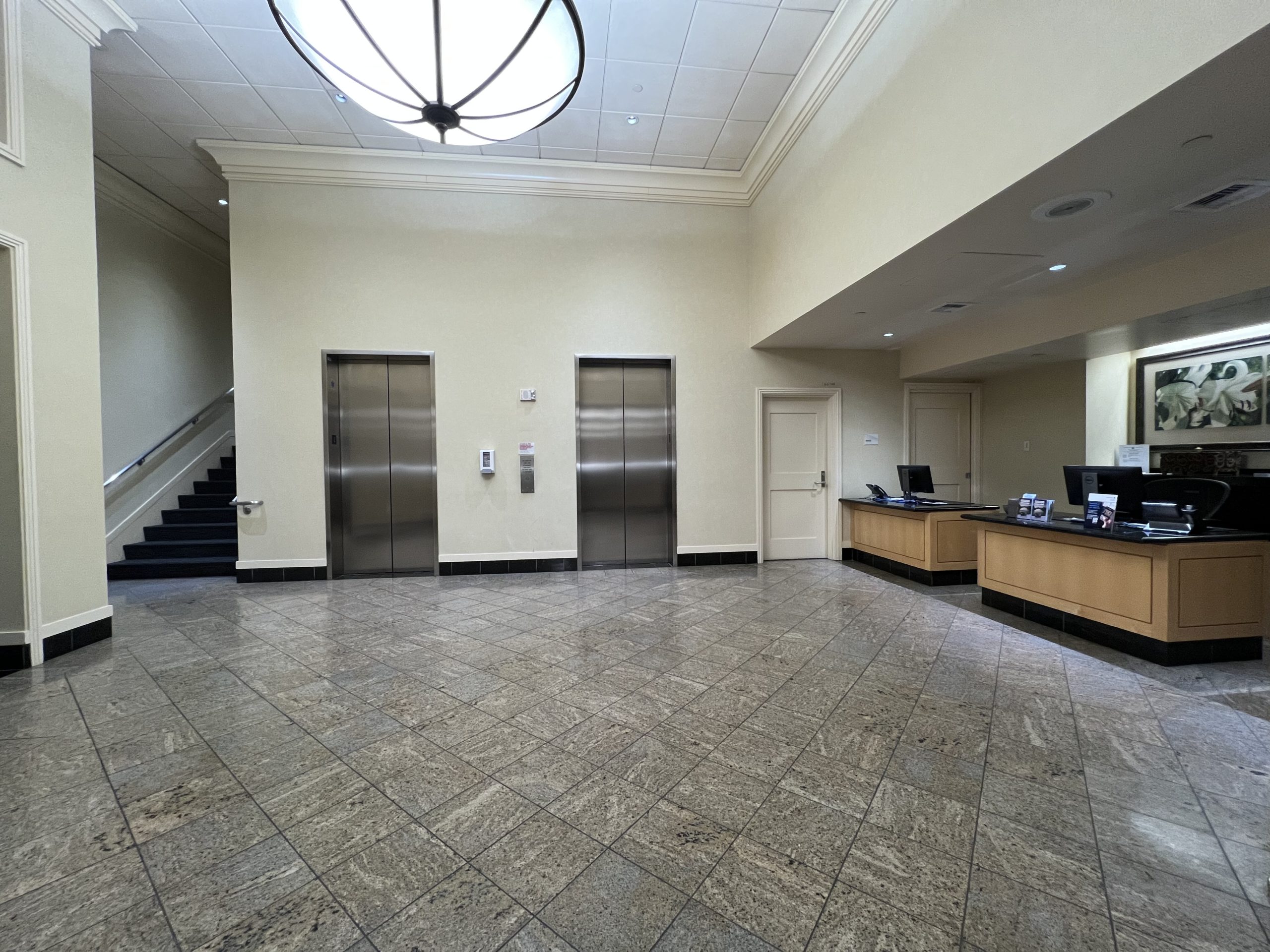 an empty lobby with elevator doors and stairs