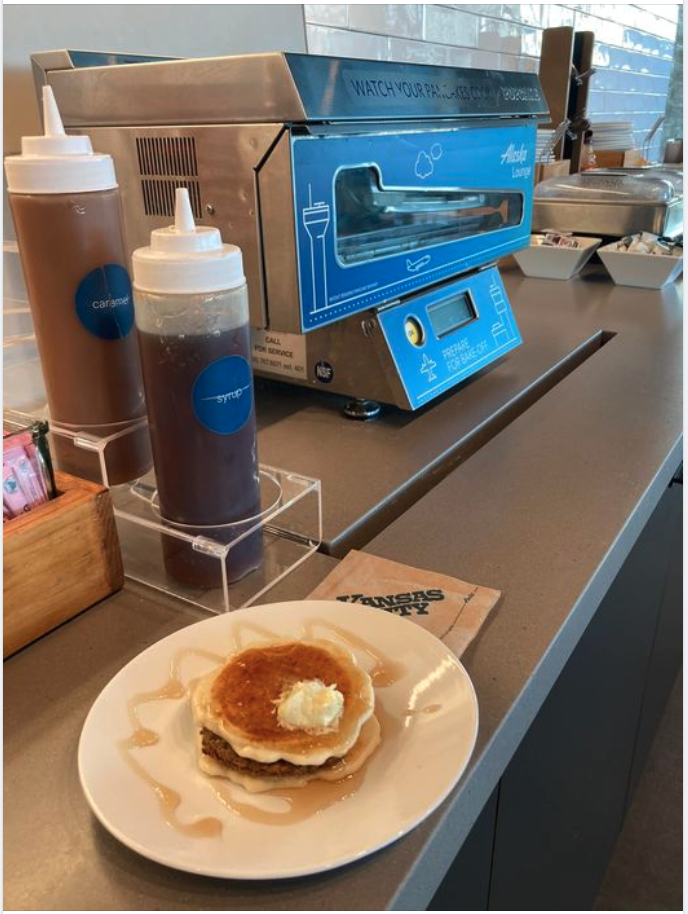 a plate of pancakes and syrup on a counter