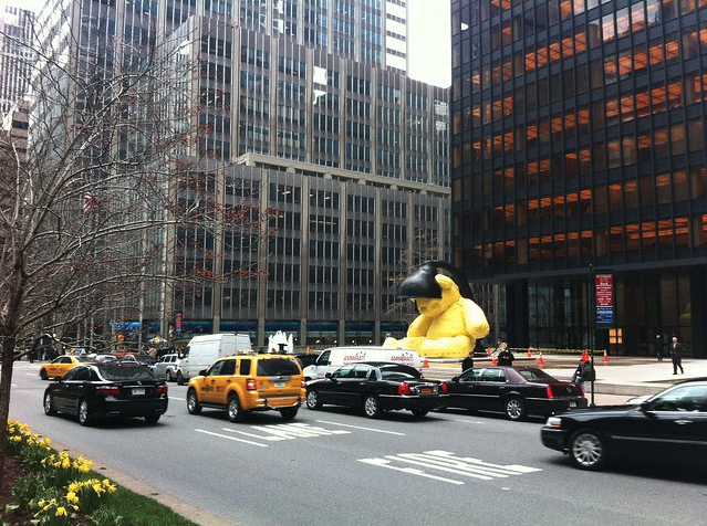 a large yellow balloon in the middle of a busy city street