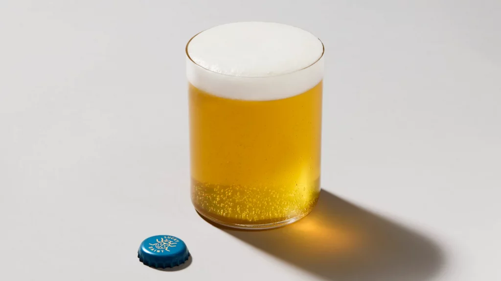 a glass of beer and a cap