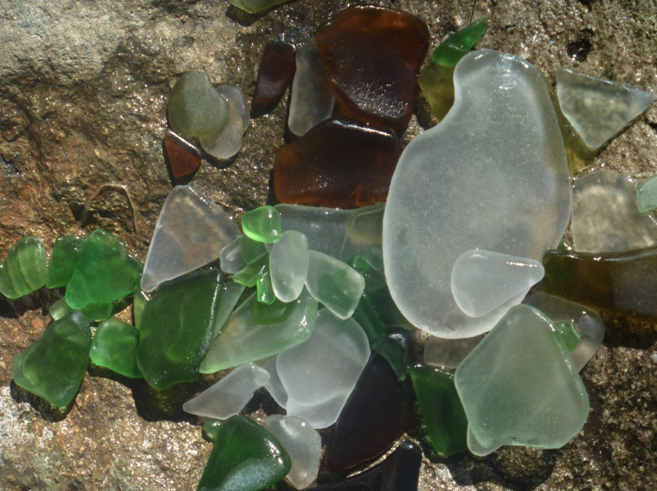 a group of sea glass pieces on a rock