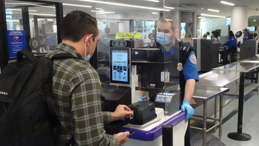 a man wearing face masks and gloves at a check-in counter