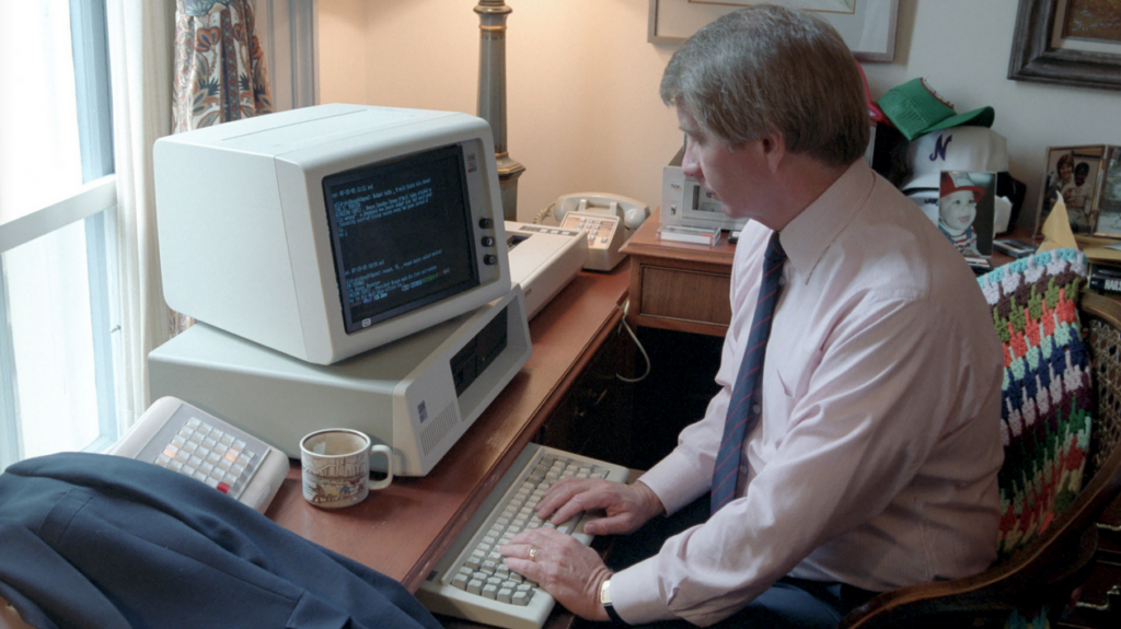 a man sitting at a desk using a computer