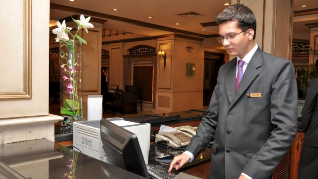 a man in a suit and tie standing at a desk