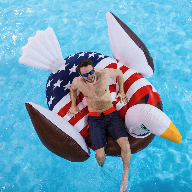 a man on an inflatable bird floating in a pool