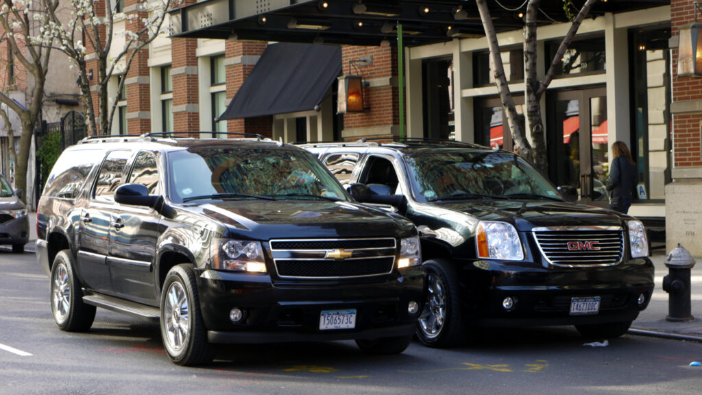 a black suvs parked in front of a building