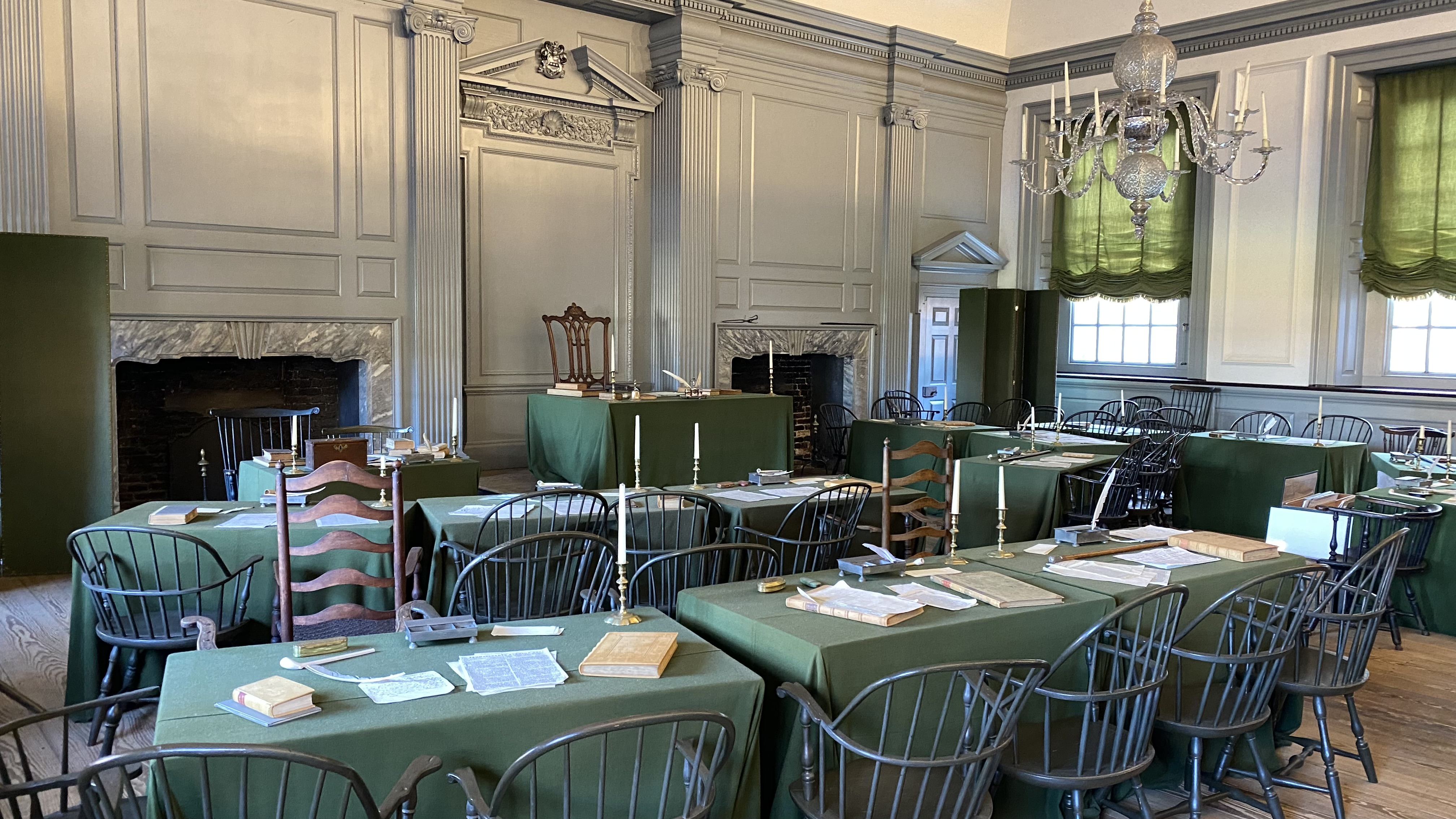 a room with tables and chairs with Independence Hall in the background