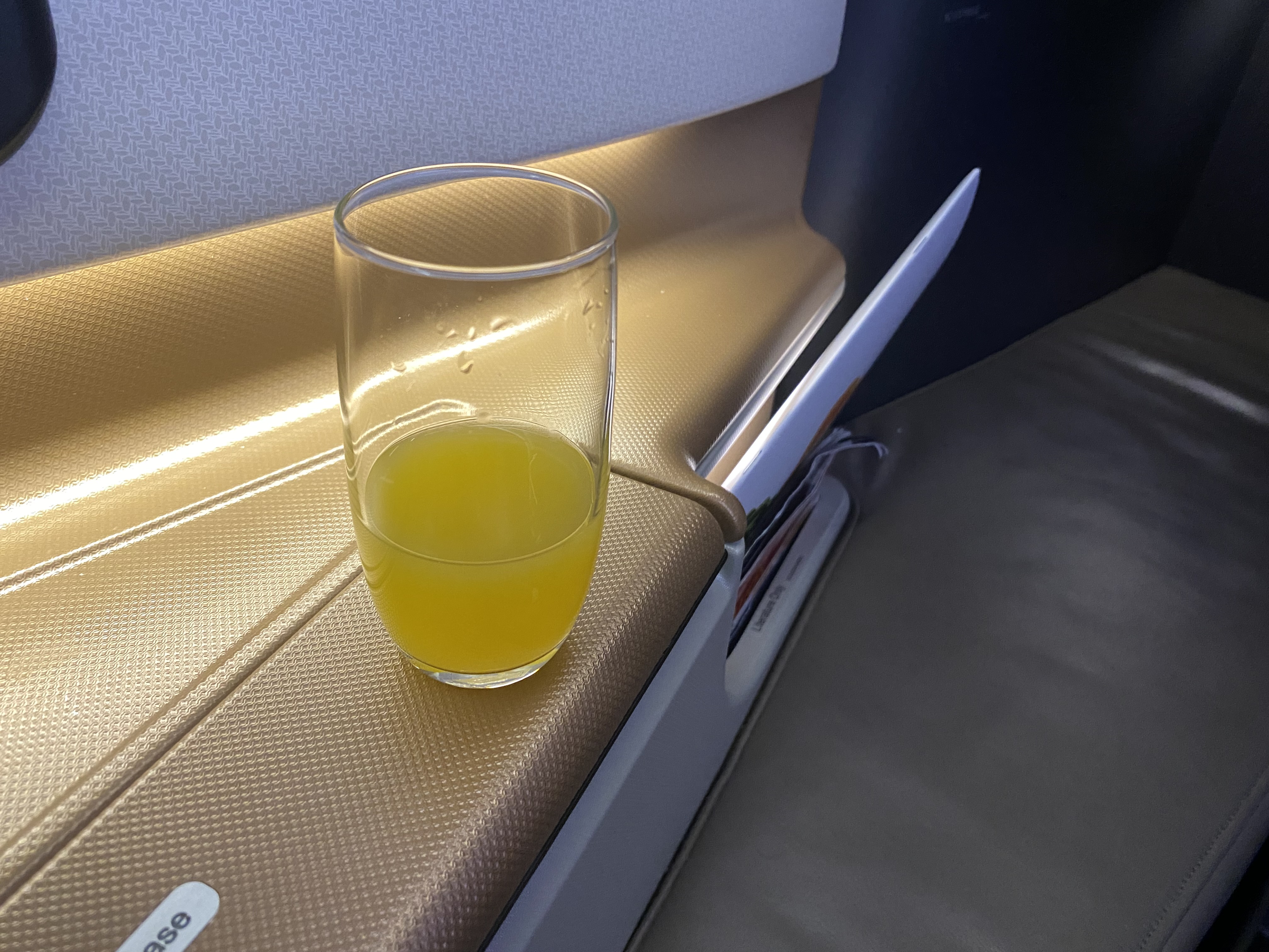 a glass of orange juice on a seat