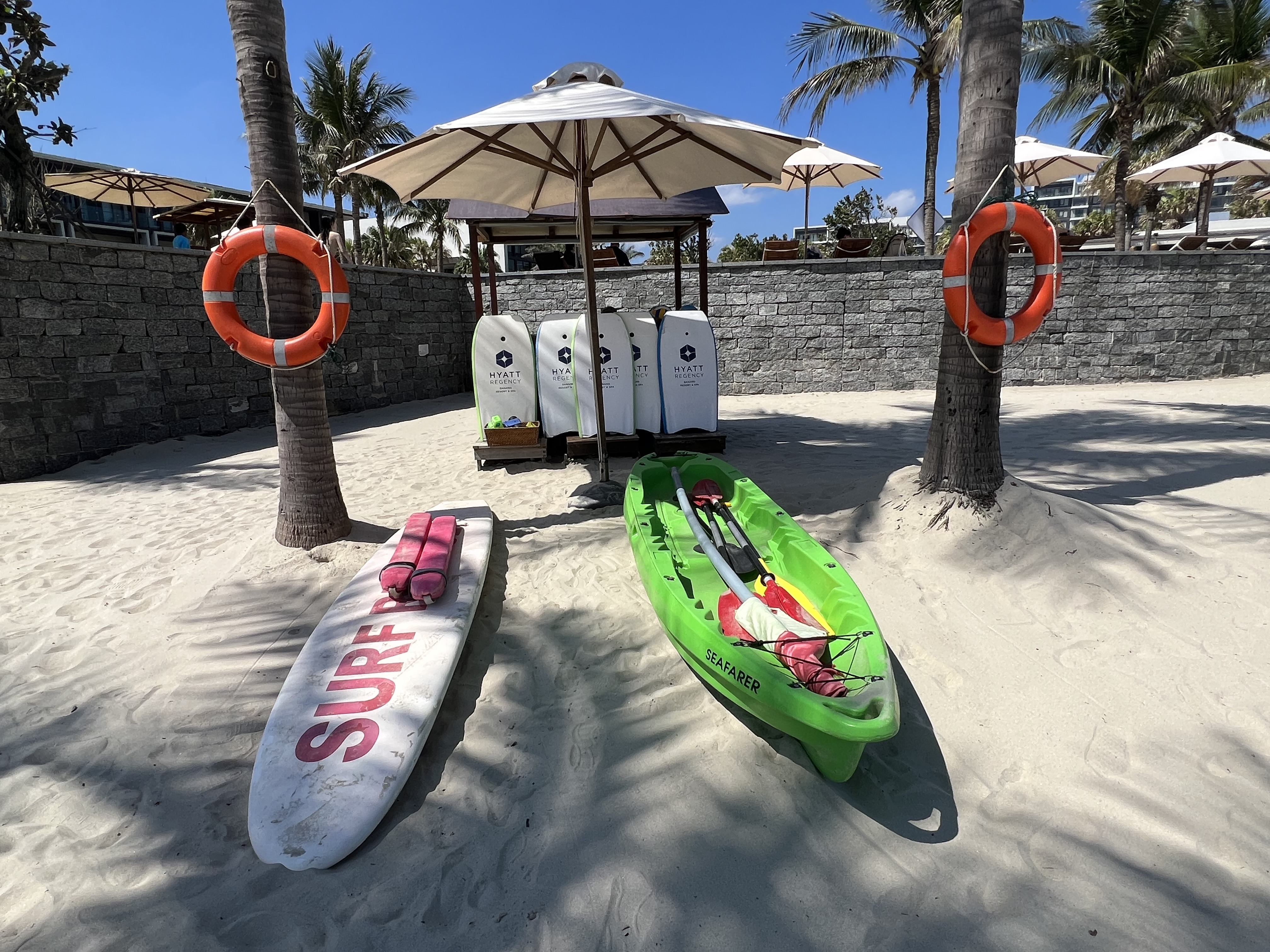 a group of surfboards and life buoys on a beach