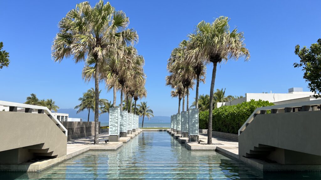 a pool with palm trees and a blue sky