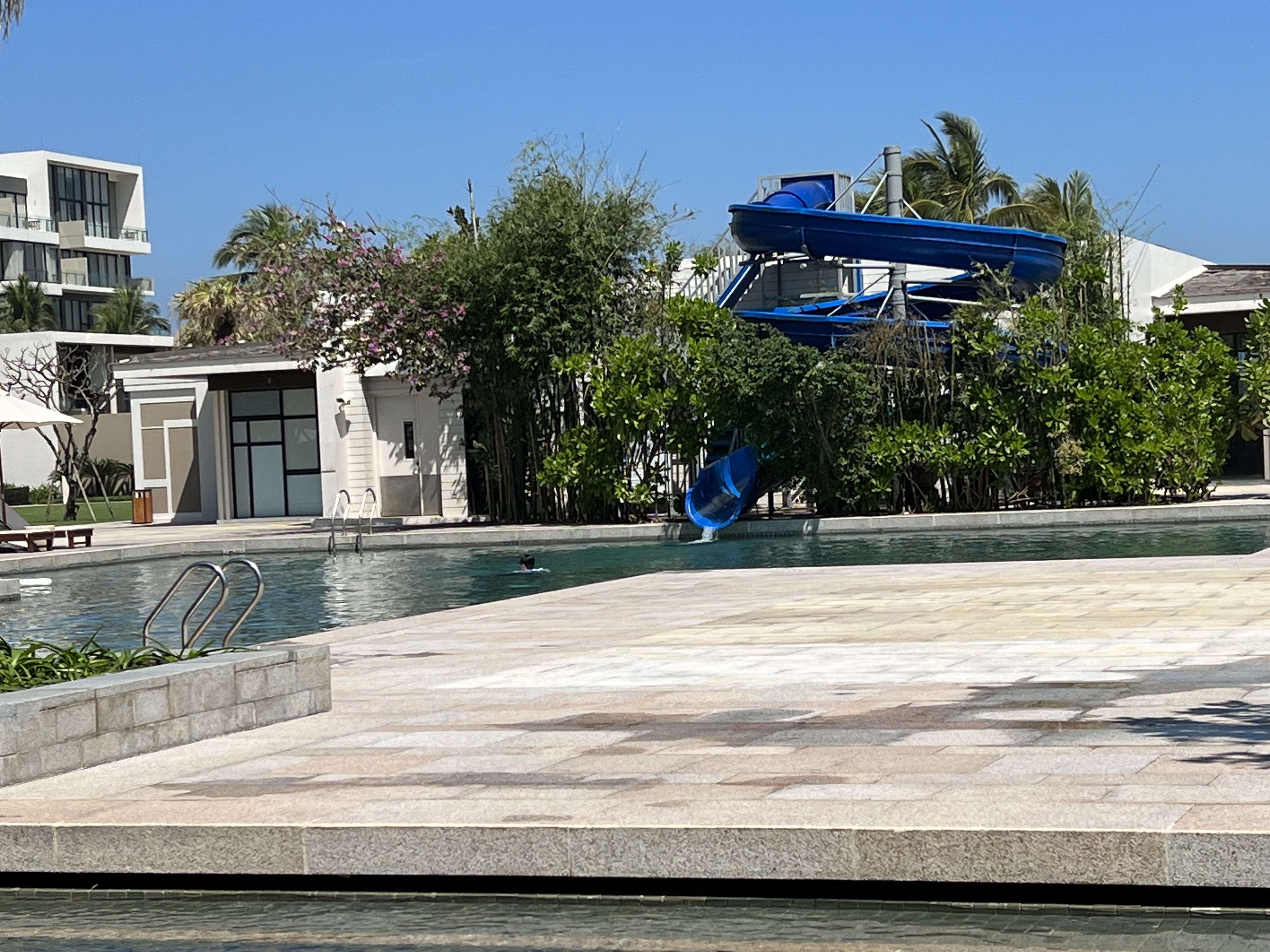 a pool with a slide and a building