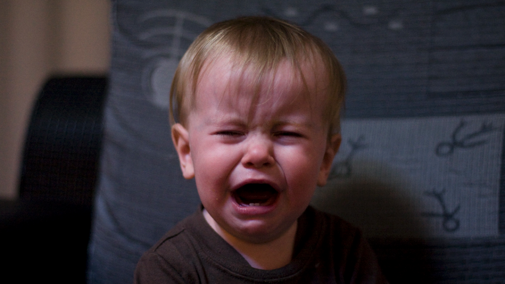 a baby crying in a chair