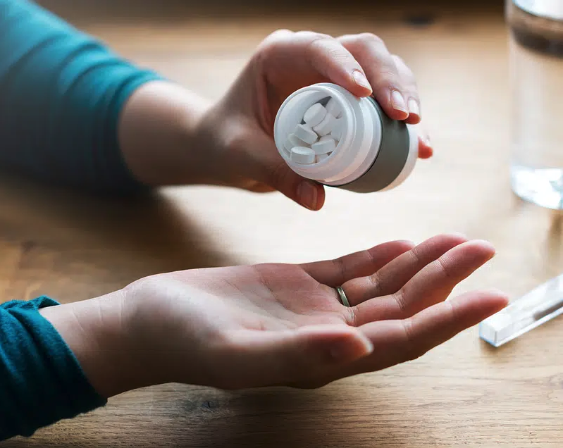 a person holding a bottle of pills