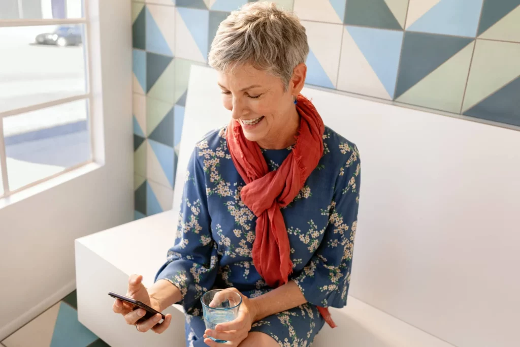 a woman sitting on a bench looking at a phone