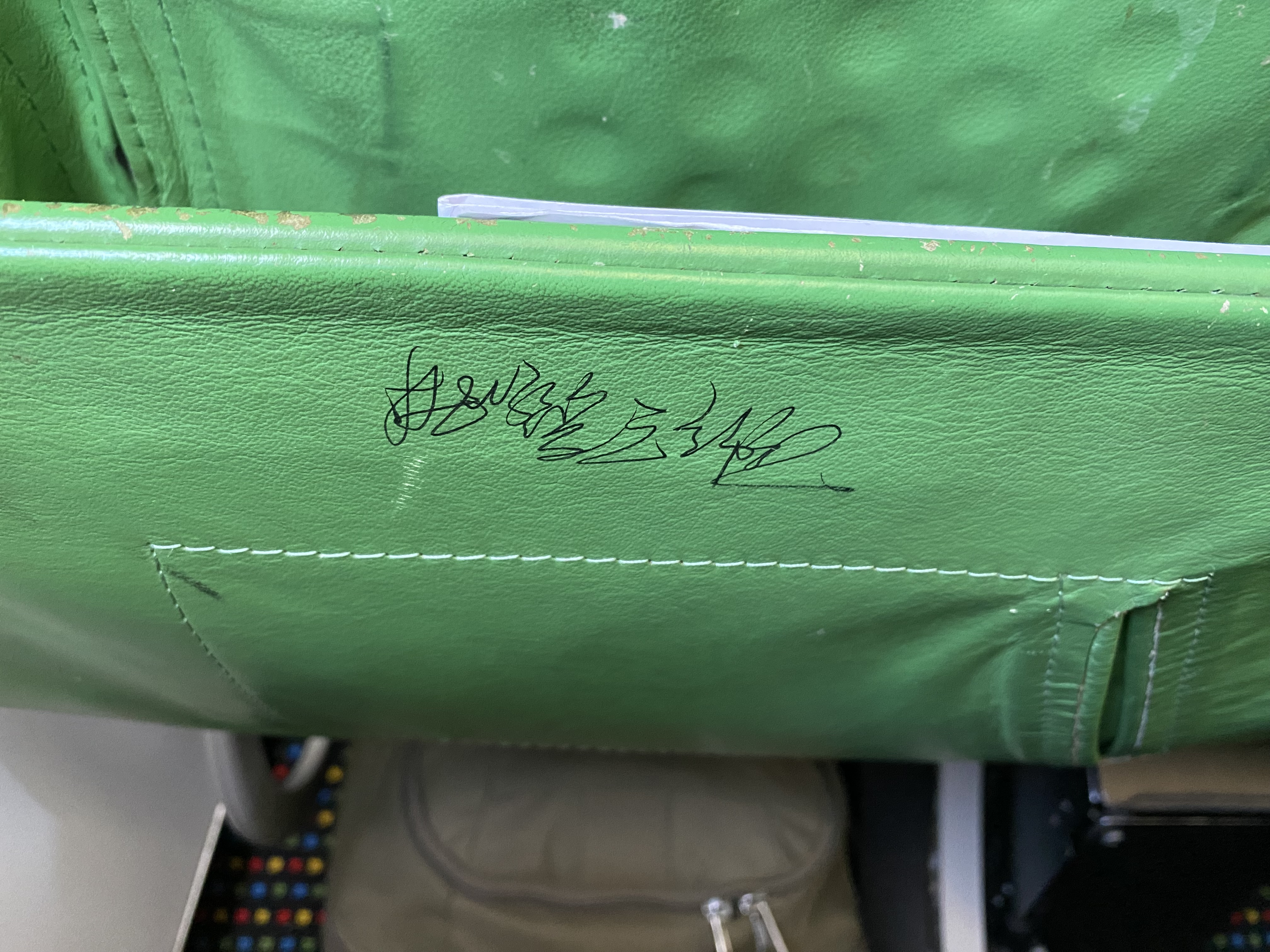 a green leather chair with writing on it