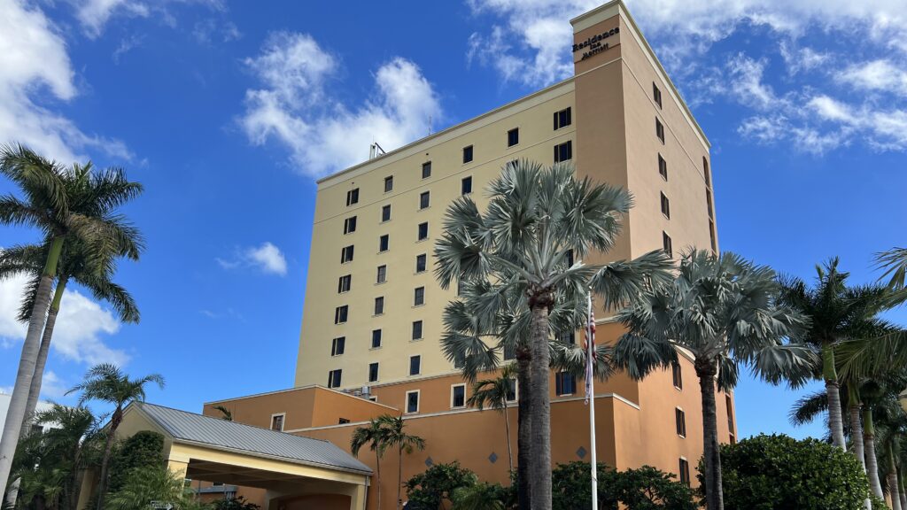 a building with palm trees and a flag