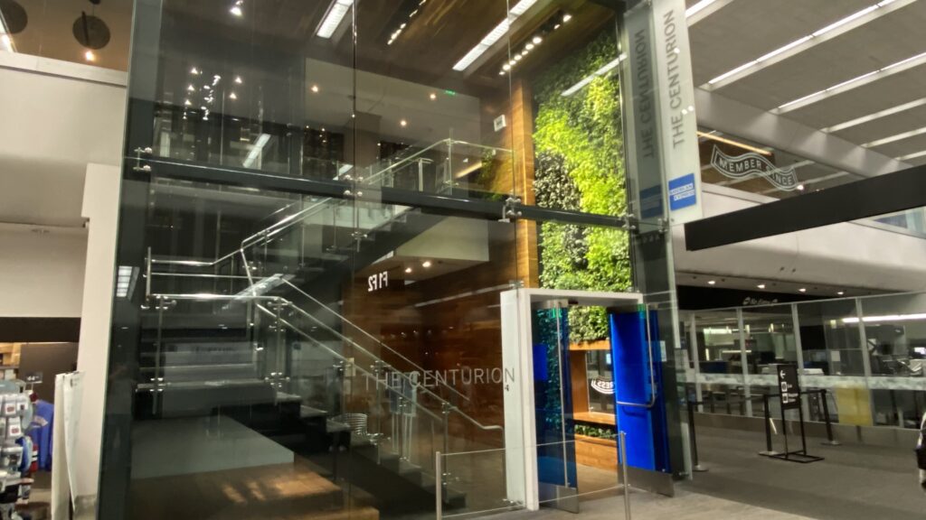 a glass wall with stairs and a sign