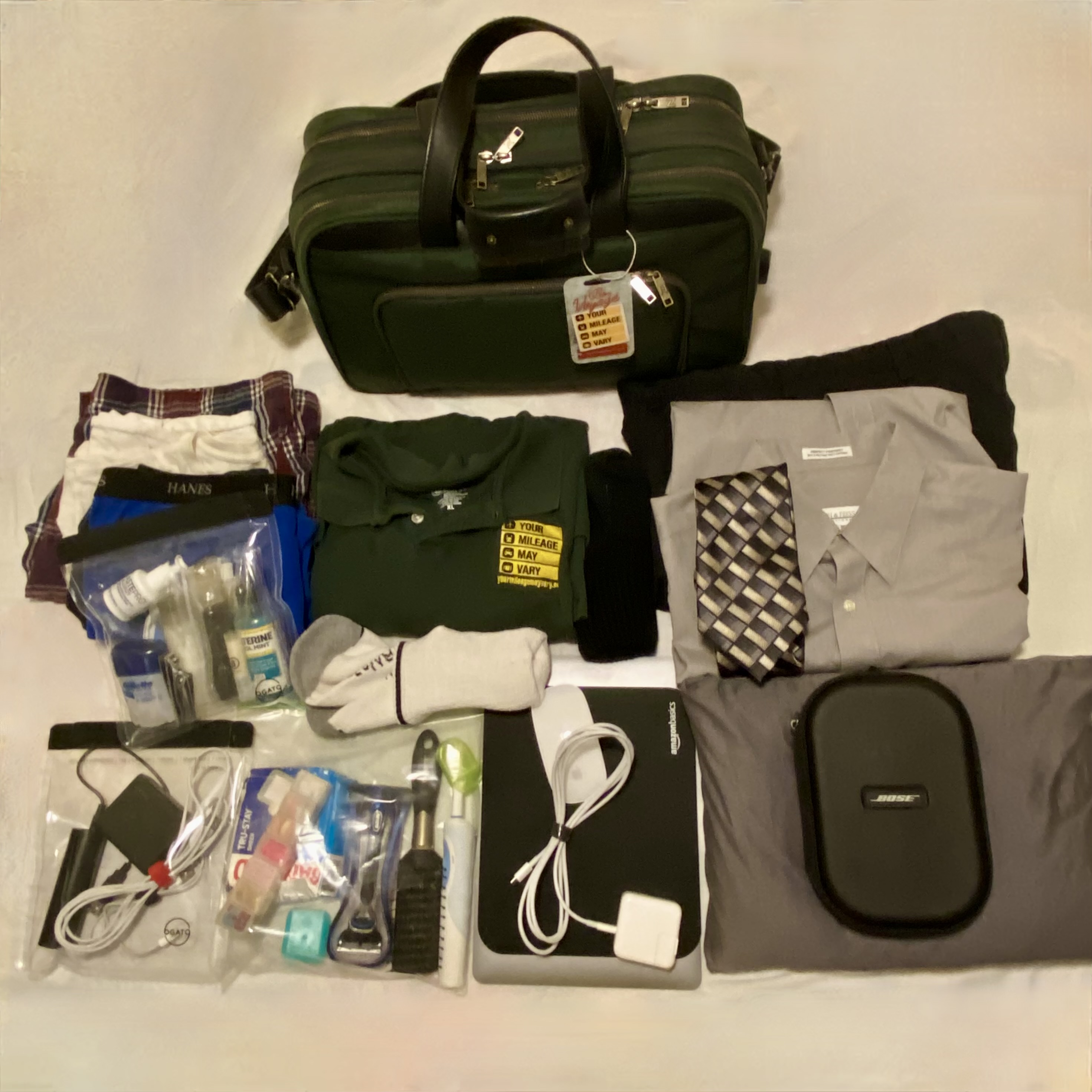 a green bag with clothes and other items in it