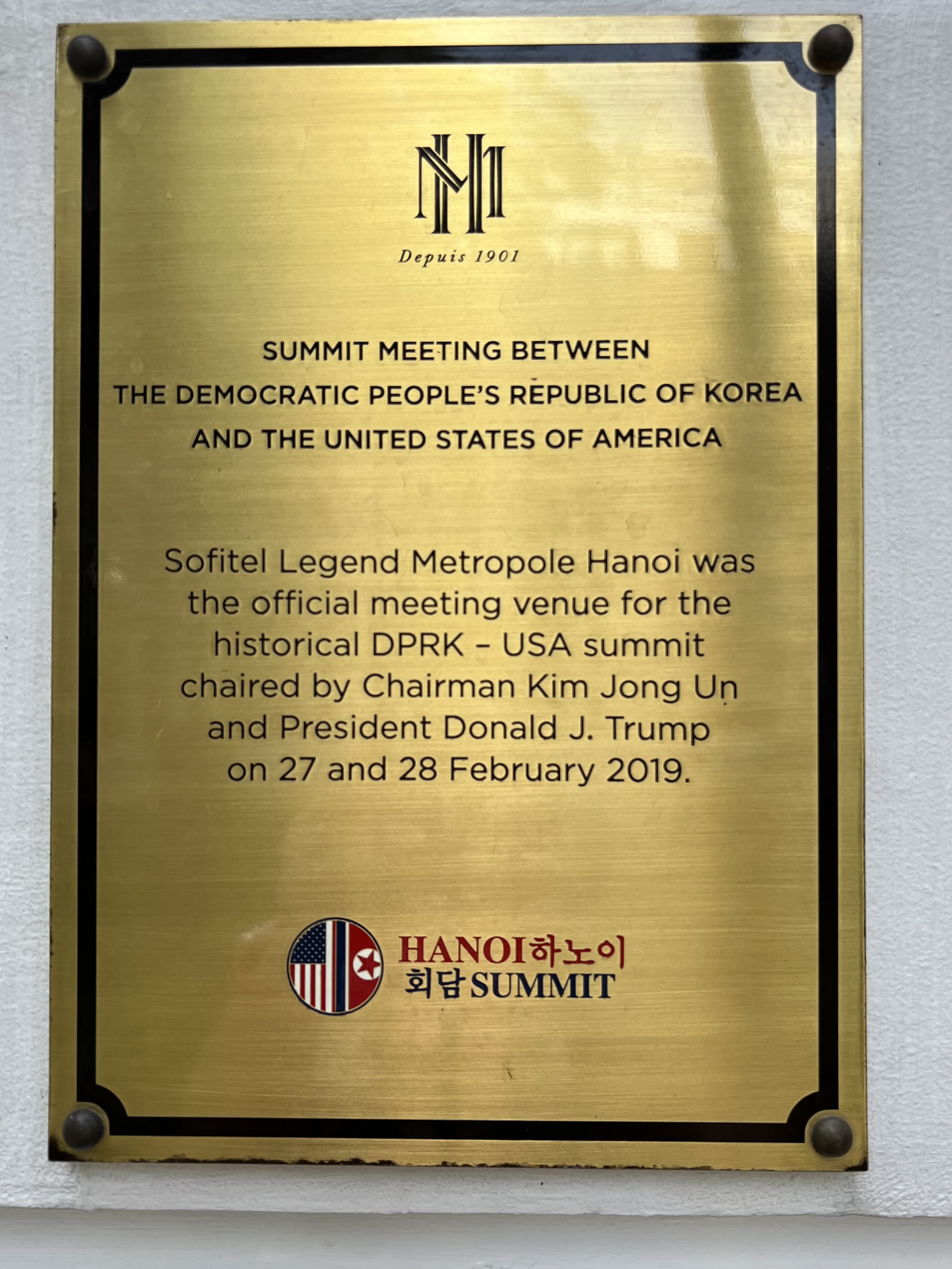 a gold plaque with black text and a logo