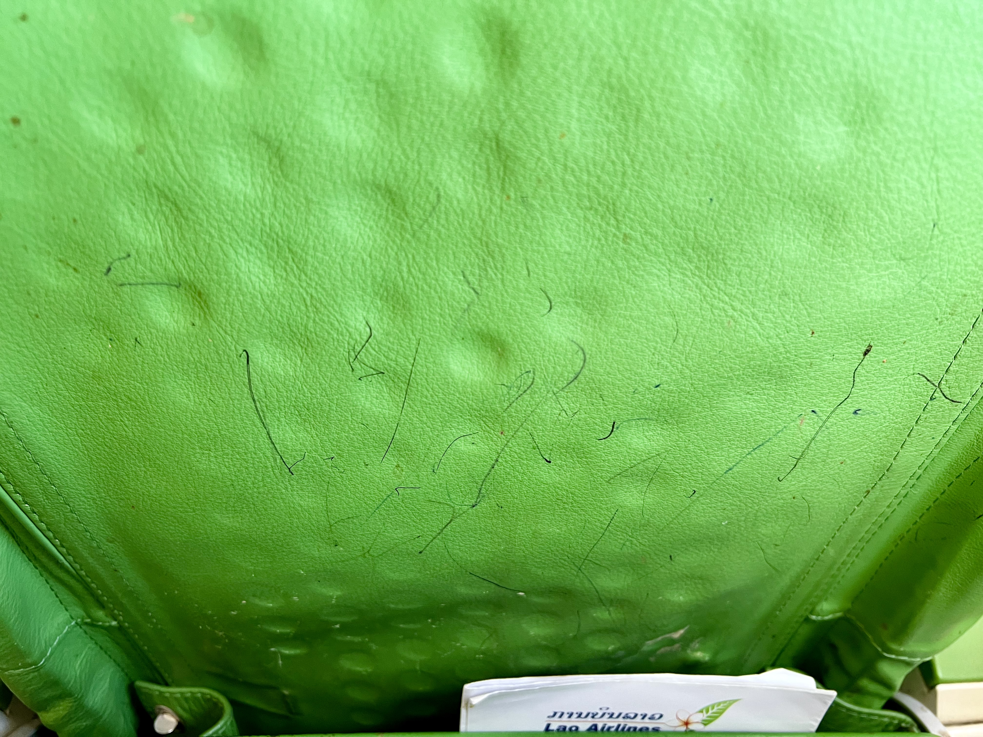 a green leather surface with black marks