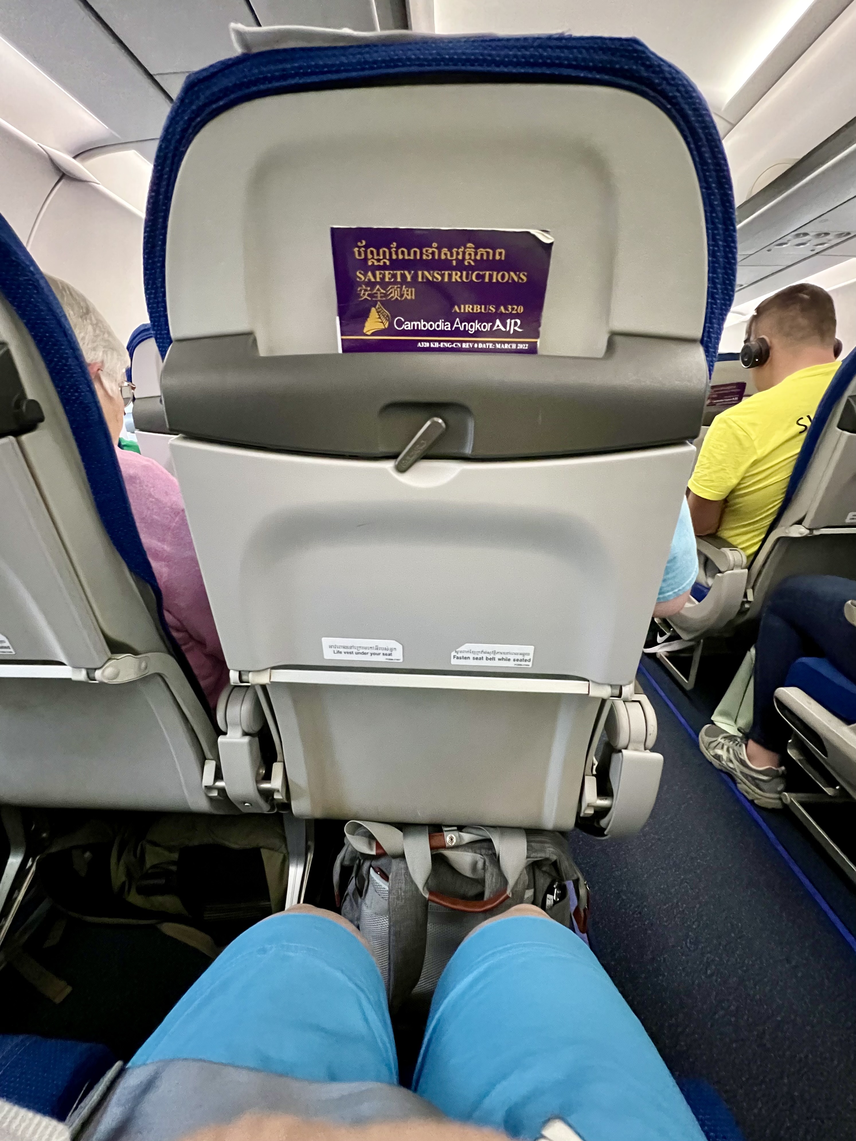 an airplane seat with people sitting in the back