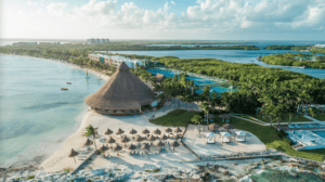 a beach with a hut and a pool and trees