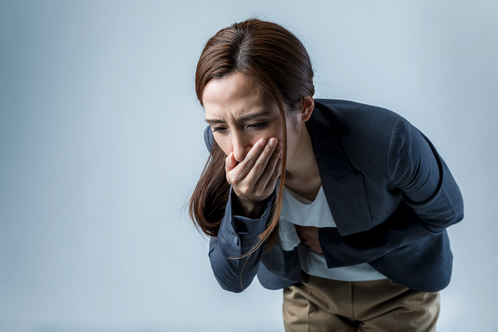 a woman holding her mouth to her mouth