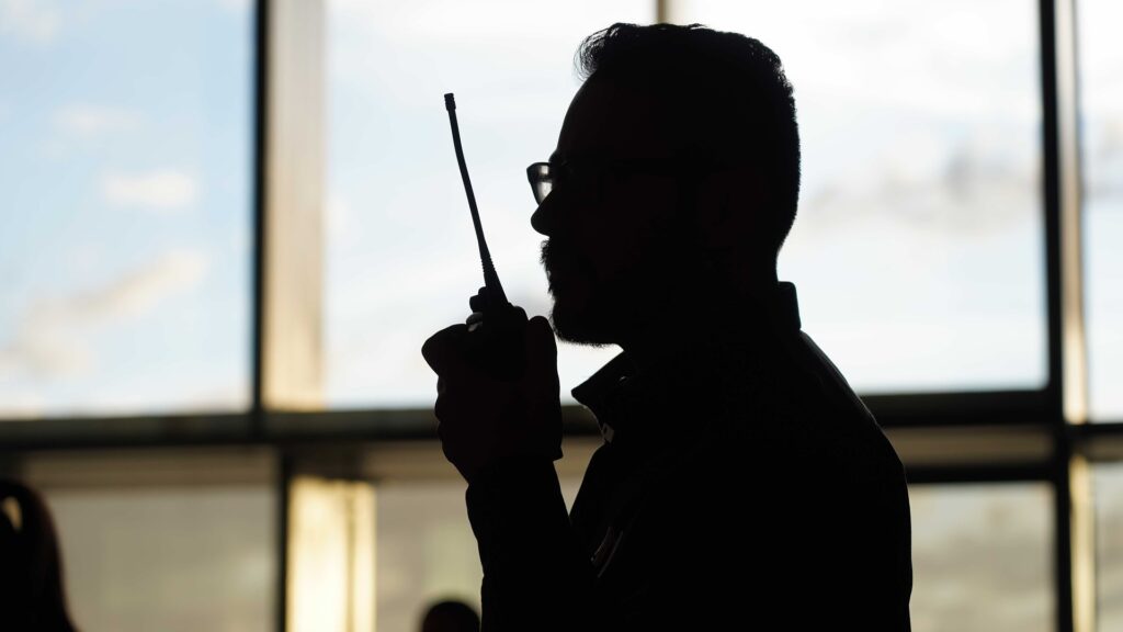 a silhouette of a man holding a radio