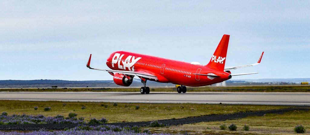 a red airplane on a runway