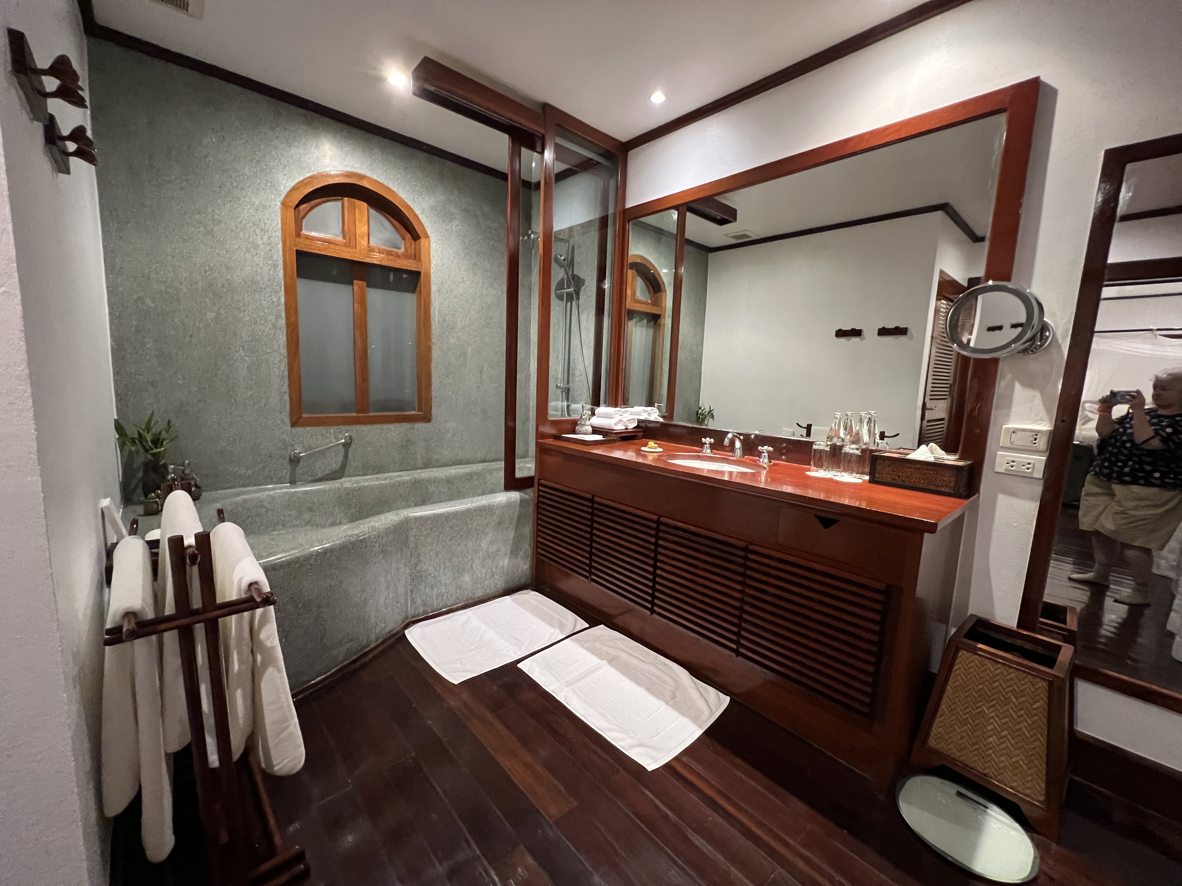 a bathroom with a wood floor and a large mirror