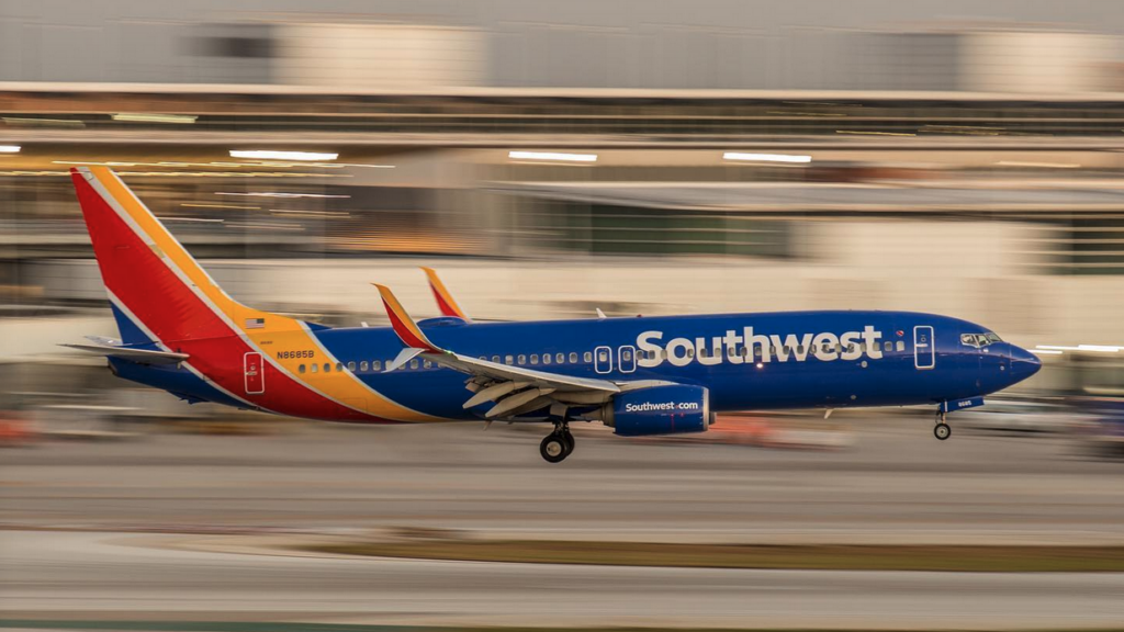 a blue and red airplane taking off