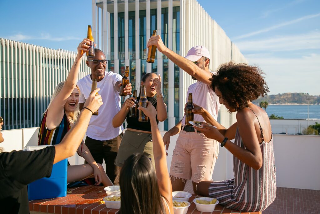 a group of people holding bottles of beer