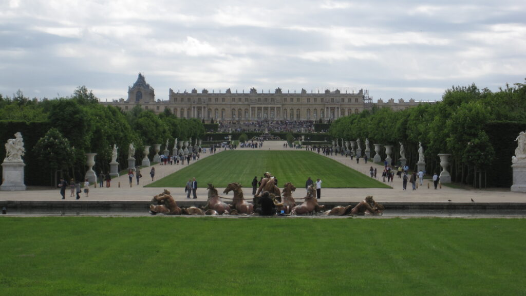 a group of people in a park with statues in front of a building