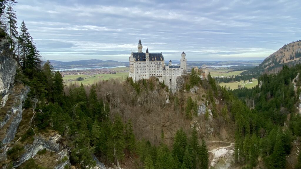 a castle on a hill with Neuschwanstein Castle in the background