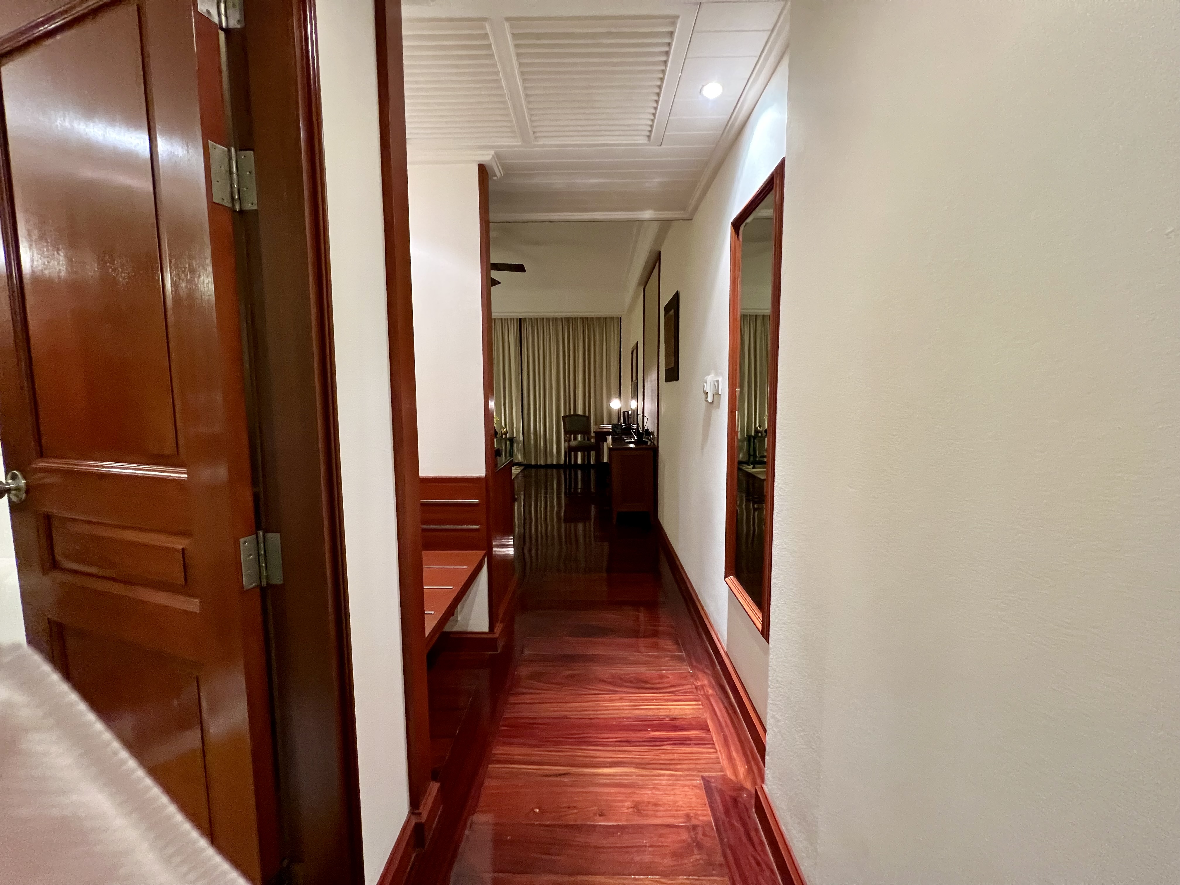 a hallway with wood floors and a mirror
