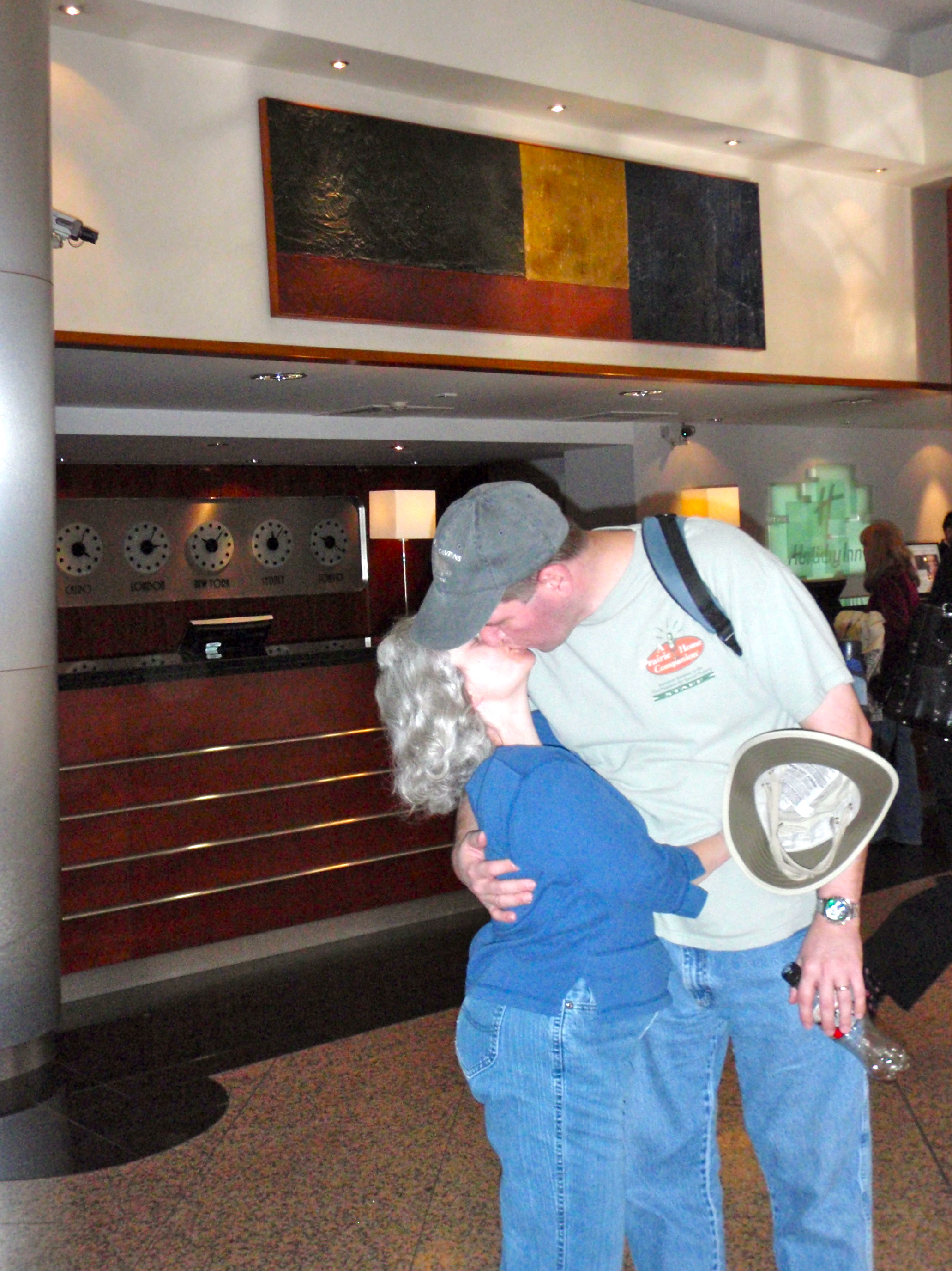 a man and woman kissing in a lobby