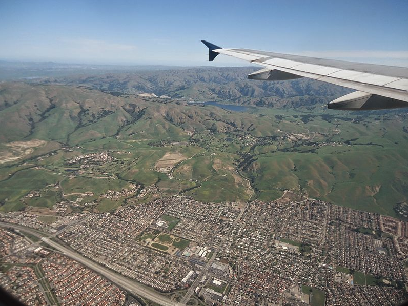 an airplane wing above a city