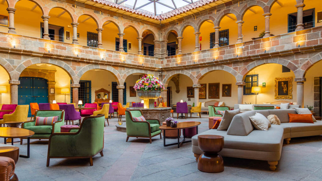 a room with a large stone building with a fountain and colorful furniture