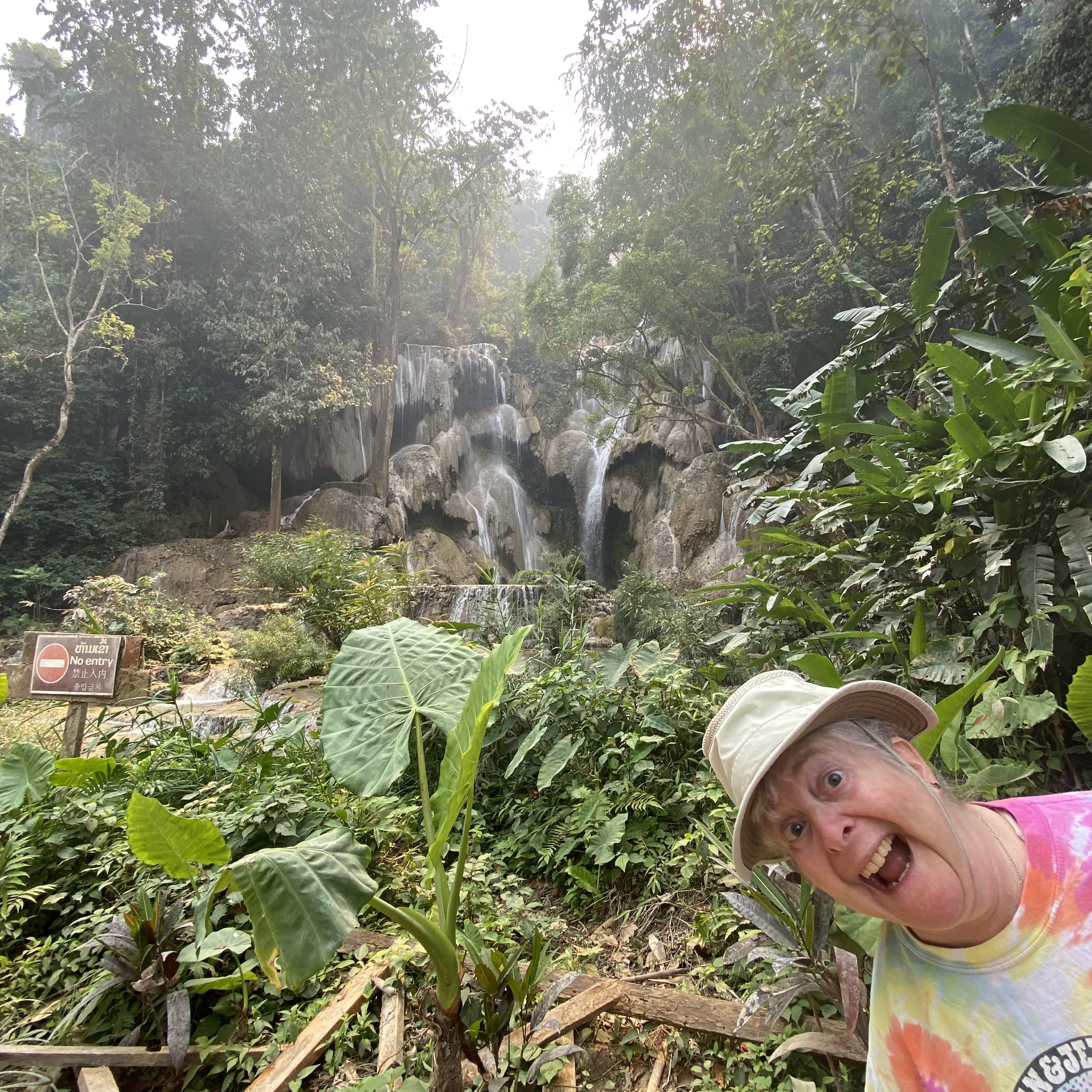 a woman taking a selfie in front of a waterfall