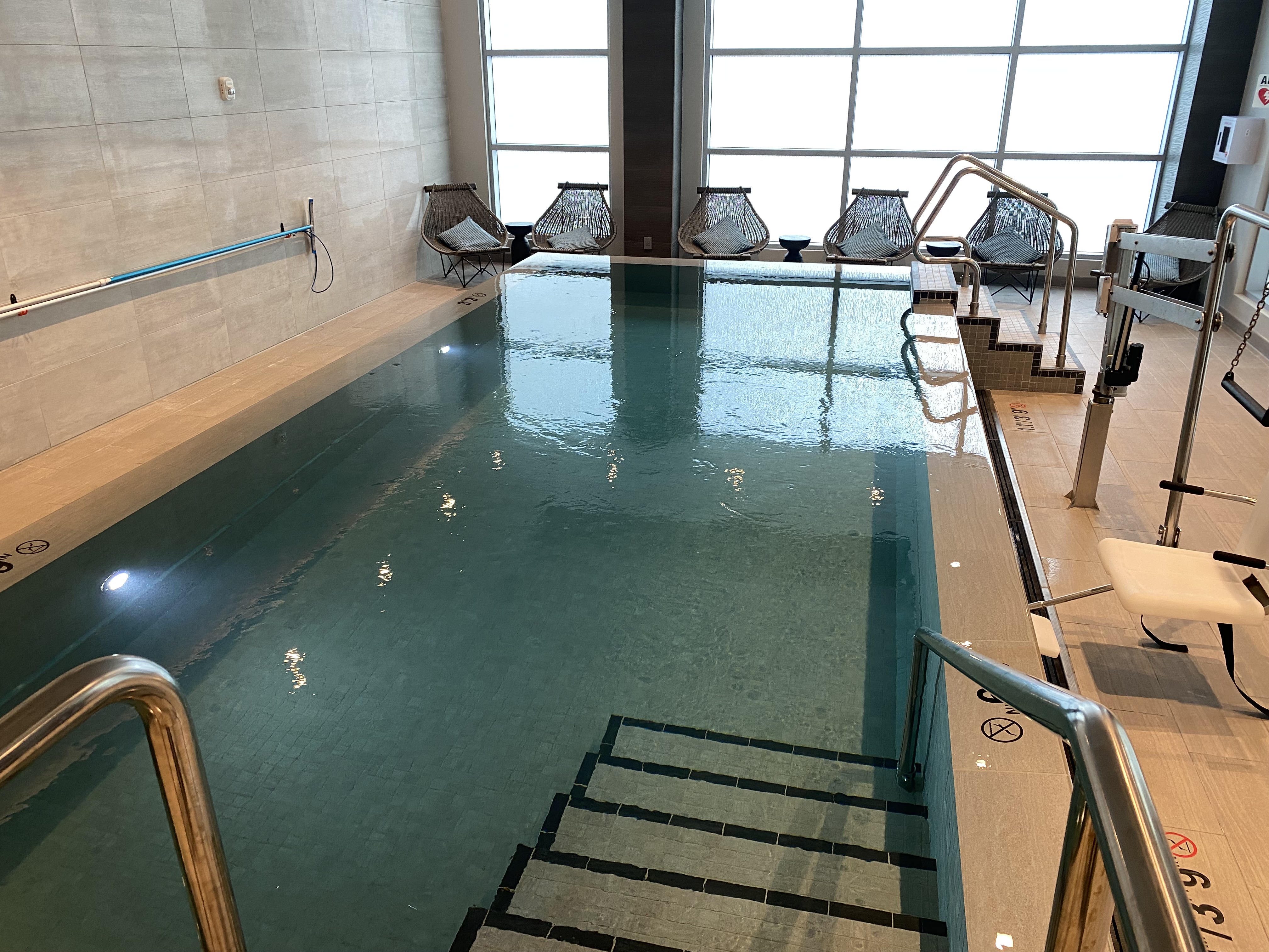 a indoor pool with stairs and chairs