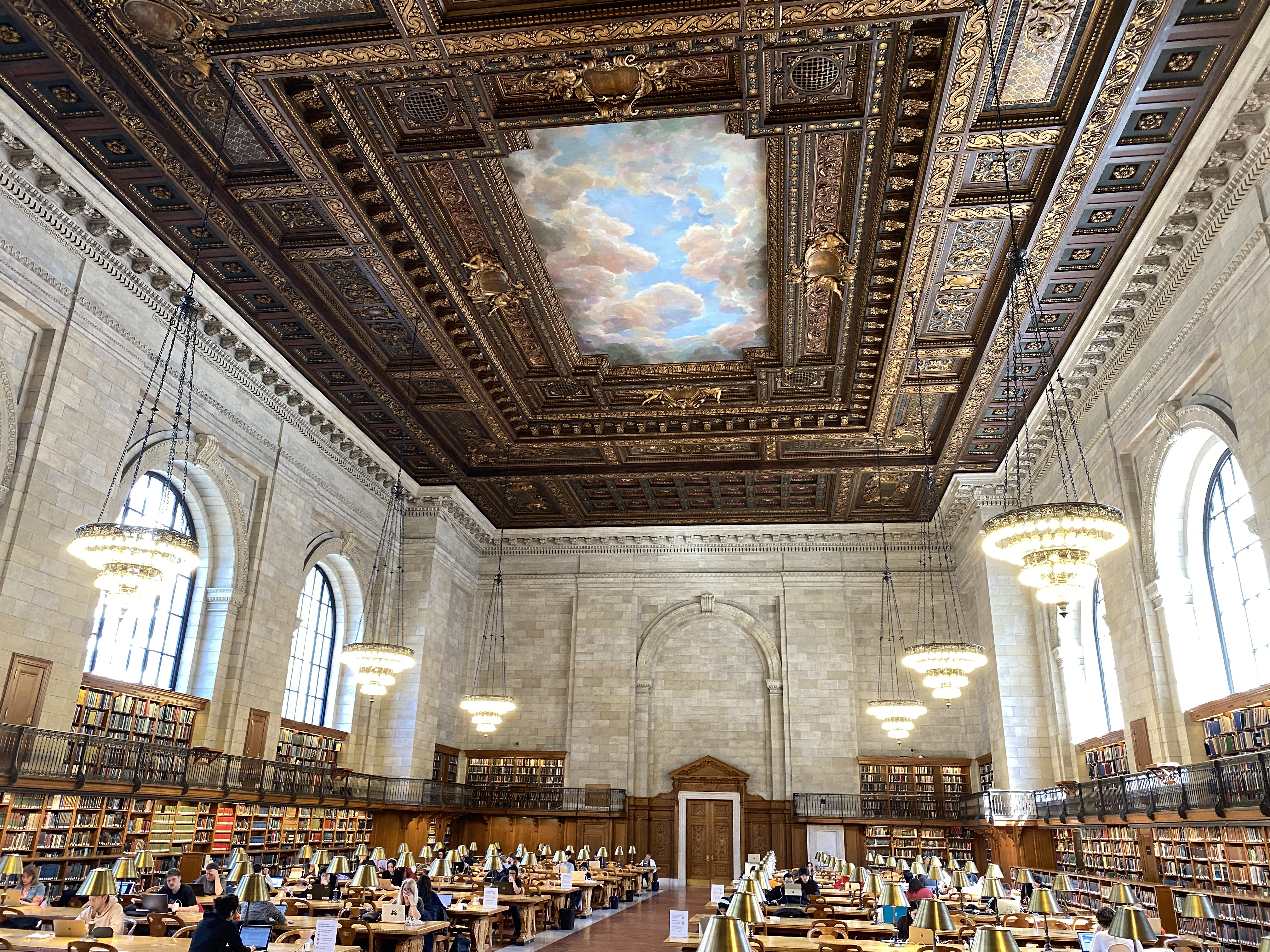 a large room with many books and a ceiling with a painting on the ceiling