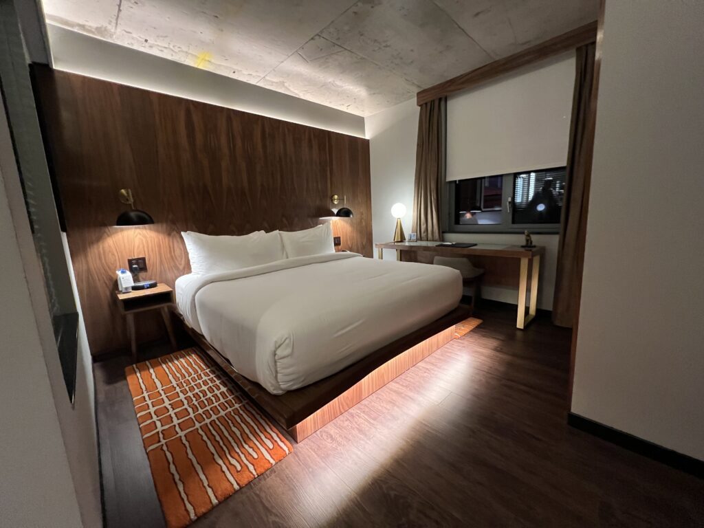 a bed with a wood paneled wall and a tv