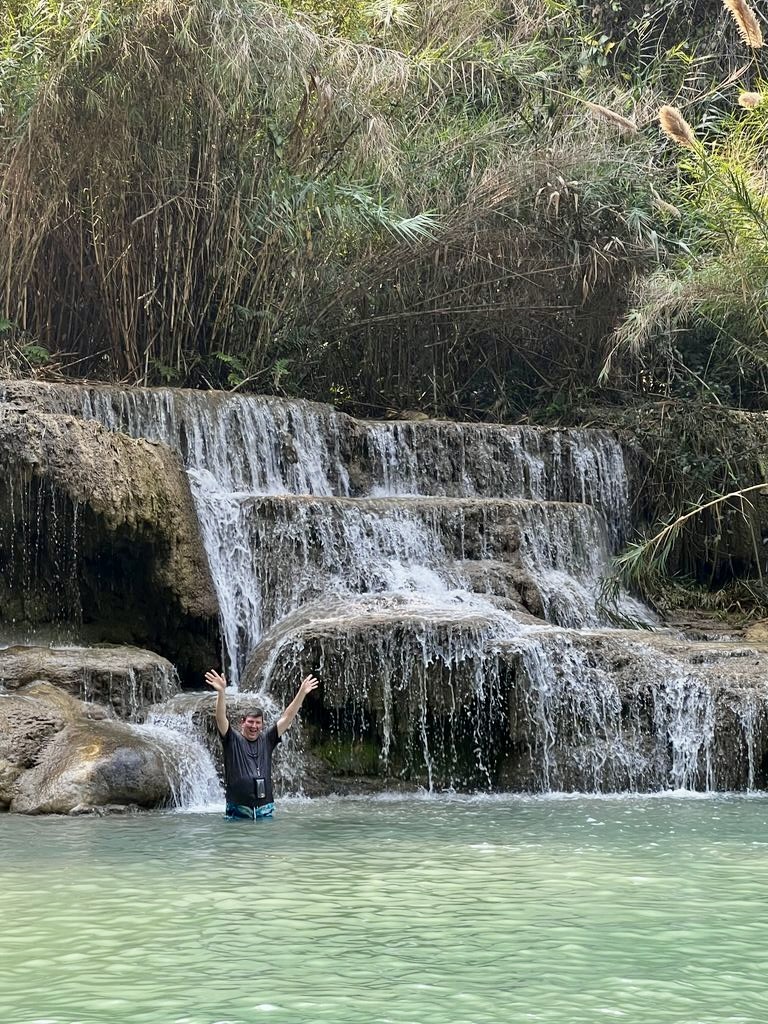 a man standing in water with his arms up