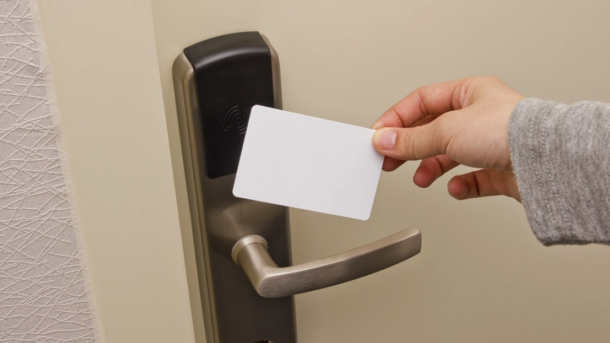 a person holding a card in front of a door handle