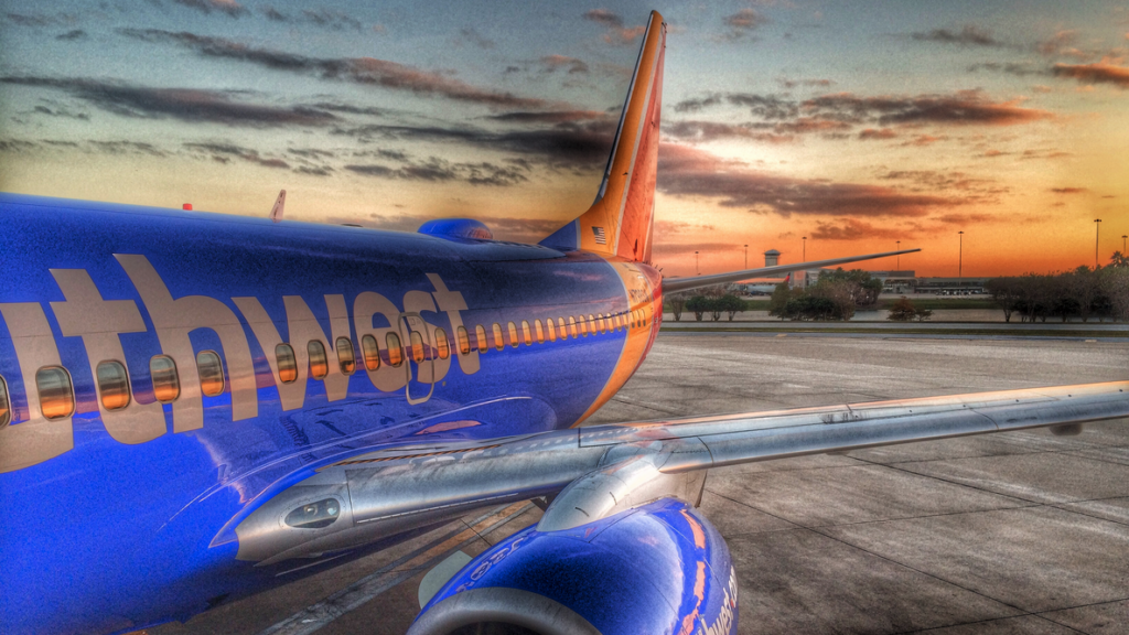 a blue and orange airplane on a runway