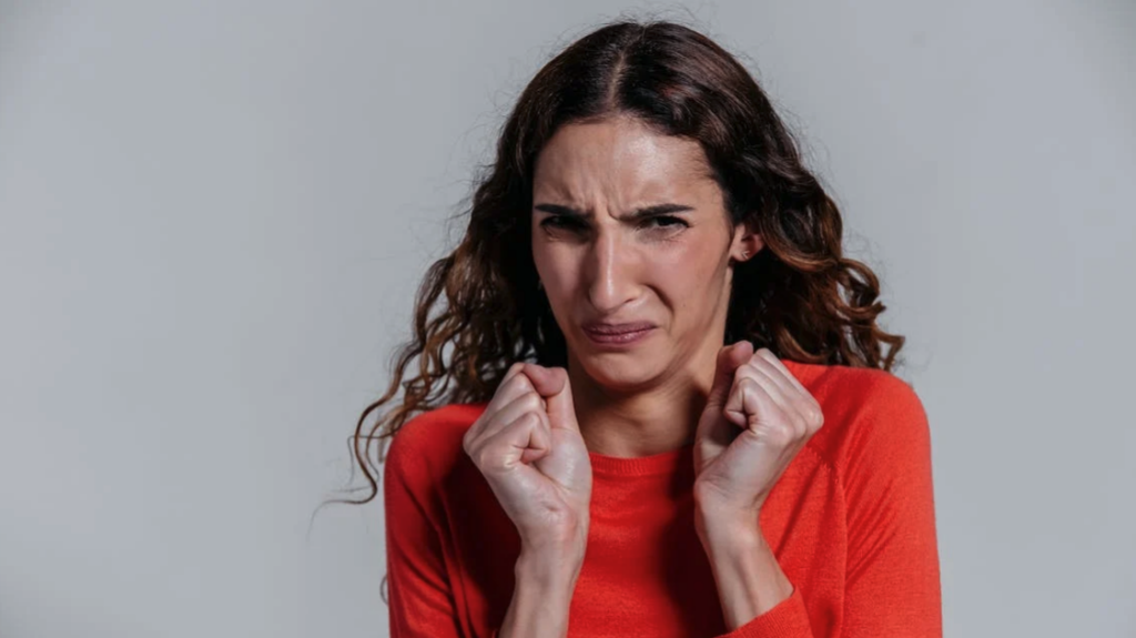 a woman with her fists in her mouth