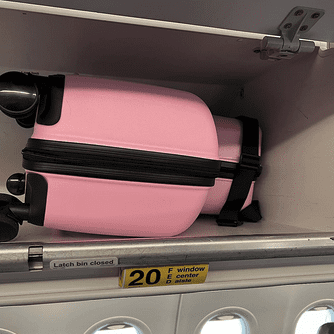a pink luggage in a shelf