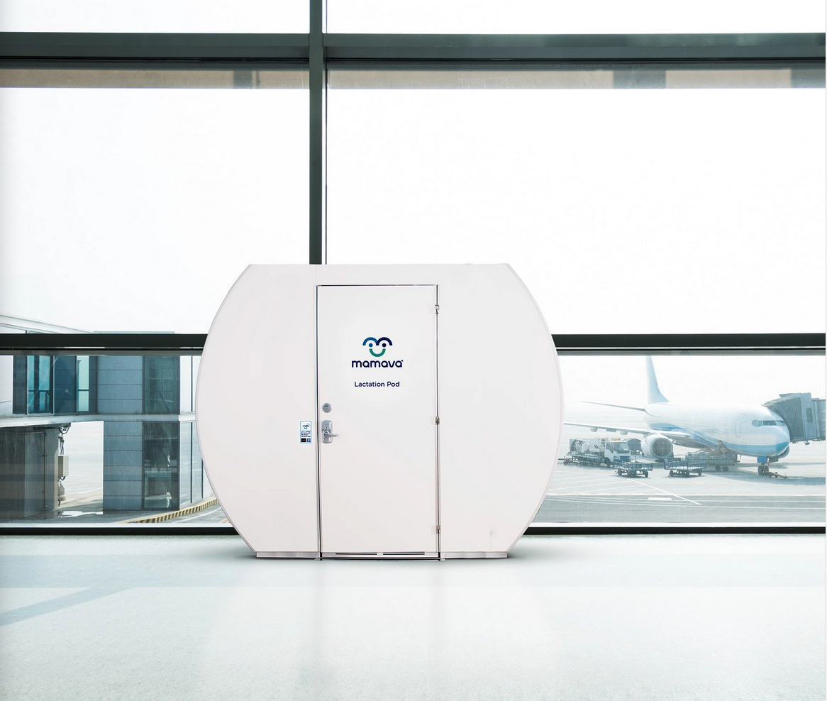 a white door in a room with windows and an airplane in the background